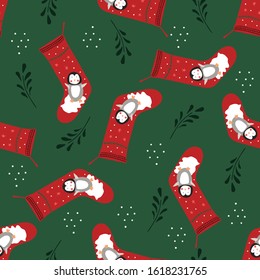 Seamless pattern of Christmas stockings with cute penguins on a dark green background.