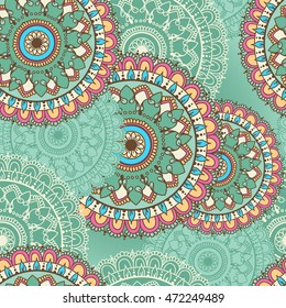 Seamless pattern with circular floral ornament. Background with mandalas for the greeting cards, invitation, business style, textile backgrounds or else. Vector illustration in turquoise colors.