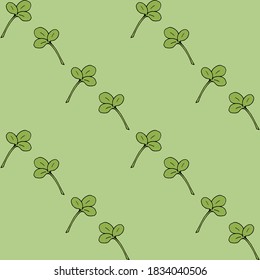 Patrón sin foco con hojas de trébol sobre fondo verde claro. Imagen vectorial. 