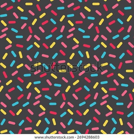 Seamless pattern of colorful candy sprinkles (red, pink, yellow, blue) on a dark gray background