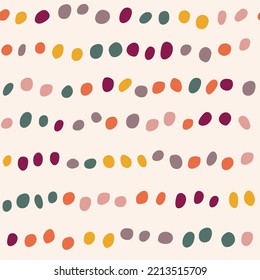 Seamless pattern with colorful dots on the beige background. Confetti Background. Modern abstract pattern with polka dots. For the design of textiles, wrapping paper, wallpaper.