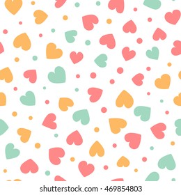Seamless pattern with colorful hearts and dots on a white background. Vector repeating texture.