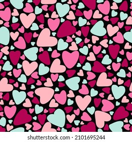 Seamless pattern of colorful hearts on a black background. Flat design in pink and emerald colors. Vector illustration.
