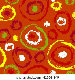 Seamless pattern of colorful swirls in yellow, green and red over orange