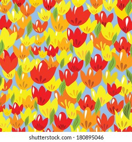 Seamless pattern with colorful tulips (red, yellow, orange) on a blue background.Vector illustration.