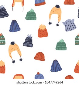 Seamless pattern of cute cozy winter knit hats and caps.  Hand drawn vector colorful funny cartoon style illustration. 