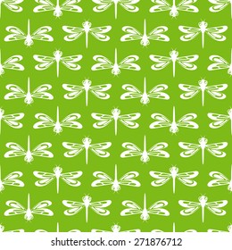Seamless pattern with cute dragonflies on green background