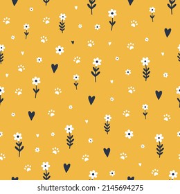 Seamless pattern with cute small flowers, hearts and cat\dog paws on yellow background.