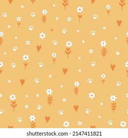 Seamless pattern with cute small flowers, hearts and cat\dog paws on yellow background.