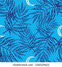 Seamless pattern of dark blue tropical tree branches on a bright blue background. Vector design. Repeat pattern of moon and polka dots with tropical floral print.  