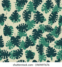 Seamless pattern with dark and light green tropical monstera leaves on a beige background. Vector.