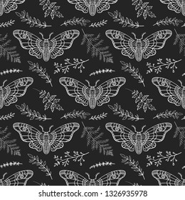 Seamless pattern. Dead head moth among the branches on a black background. Hand drawn illustration. Great for tattoo, print on a T-shirt, for decoration of Halloween and more.