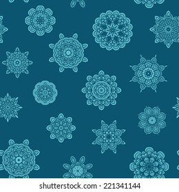 Seamless pattern with decorative snowflakes on dark turquoise background