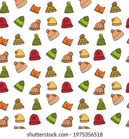 Seamless pattern with different winter hats on white background. Doodle style. Vector image.