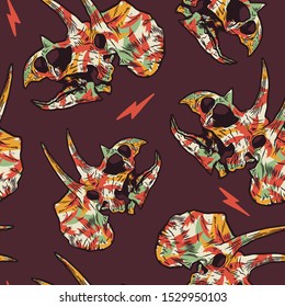 Seamless pattern of a dinosaur skull with orange, yellow ,green and brown paper cut palms background elements