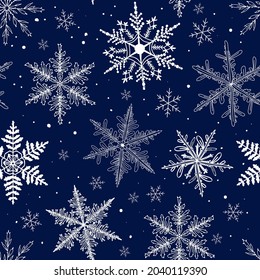 Seamless pattern with doodle snowflakes on a blue background. Christmas pattern for gifts, textiles, design of cards, sites. White snowflakes.