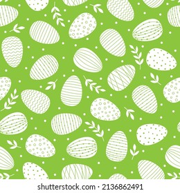 Seamless pattern with Easter decorated eggs. White eggs and branches on green background.