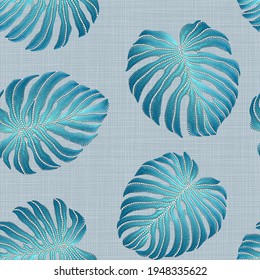 Seamless pattern of embroidered blue tropical monstera palm leaves on a linen background. Embroidery stitches imitation
