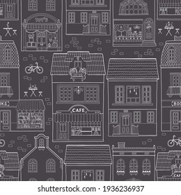 Seamless pattern with European houses. Dutch buildings with shops, bookstores, coffee shops. White outline on a dark background. Monochrome vector sketch illustration in a hand-drawn childish style