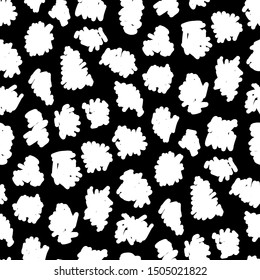 Seamless pattern of fashionable white spots on black background.
