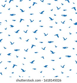 Seamless pattern flock of blue birds silhouette flying isolated on white background. Elegant gulls fly print, modern motif fabric textile cloth or wall paper, vector design eps 10