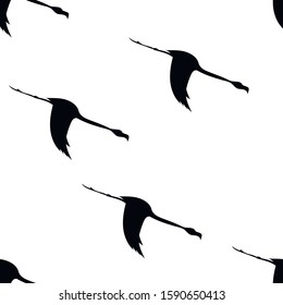 Seamless pattern of flying black silhouettes of birds, flamingos