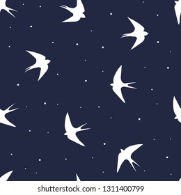 seamless pattern of flying swallow birds on dark blue background