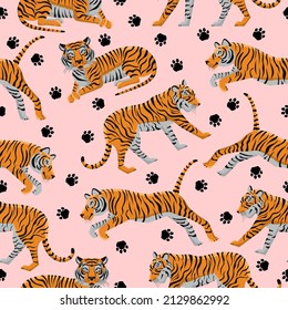 Seamless pattern with funny tigers and paw prints on a pink background. Animal template with striped wild animals. Trendy background for textiles and fabrics. Vector illustration.