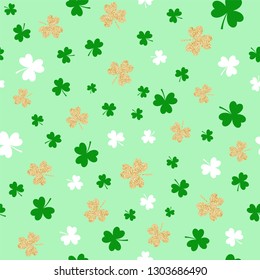Seamless pattern with glitter golden shamrocks on light green  background. Saint Patrick's Day symbols texture. Vector.