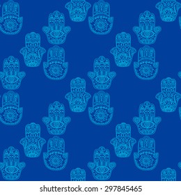 Seamless pattern with hand drawn doodle hamsa. Ethnic hand with ornament.On blue background.