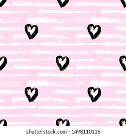 Seamless pattern with hand-drawn hearts isolated on pink striped background. Ink doodle style abstract grunge wallpaper.