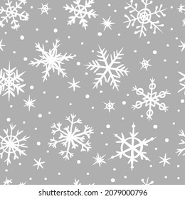 Patrón sin foco de copos de nieve dibujados a mano sobre un fondo gris. Nevada al estilo doodle. Ilustración vectorial. Patrón para el diseño invernal y navideño.