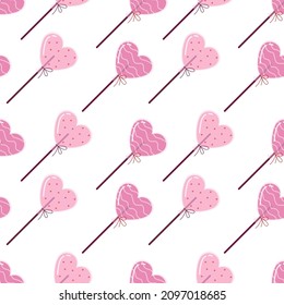 Seamless pattern with heart shaped lollipops on a light background