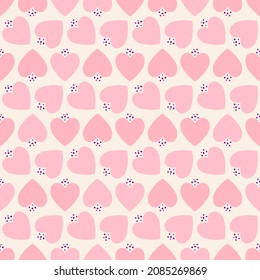 Seamless pattern of hearts in shades of pink on a cream background.
