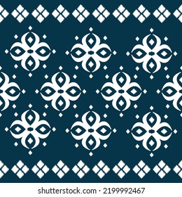 Patrón sin brillo de las formas de diamante ikat y flor blanca sobre el vector de fondo azul oscuro.