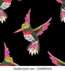 Seamless pattern. Imitation of embroidery. Embroidered birds. Satin stitch. Bird embroidered with stitches. Black background. Vintage ornament. Hand drawn. Vector illustration.