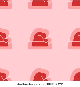 Seamless pattern of large isolated red santa claus hat symbols. The elements are evenly spaced. Vector illustration on light red background