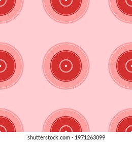 Seamless pattern of large isolated red gramophone record symbols. The elements are evenly spaced. Vector illustration on light red background
