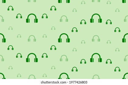Seamless pattern of large and small green headphones symbols. The elements are arranged in a wavy. Vector illustration on light green background