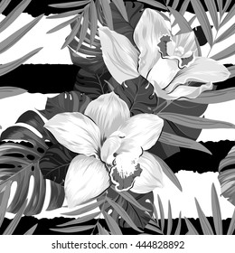 Seamless pattern of leaves monstera, palm and blooming orchids on the striped background