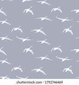 Seamless pattern of light swan silhouettes on a light grey background. Flying birds in different views. Vector pattern for textile, print.