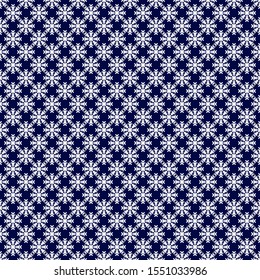 Seamless pattern. Little white snowflakes on a blue background. Vector drawing. Texture.