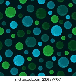 Seamless pattern of luminescent green and blue circles or balls on dark background. Neon color chaotic bubbles. Vector illustration for fabric, wallpaper or wrapping paper print, abstract design.