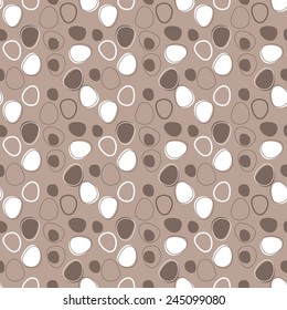 Seamless pattern.  Many white and brown decorative stones on beige background