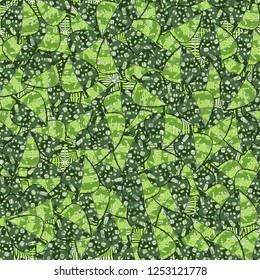 Seamless pattern. The motley-green leaves of maple lying on a background of coarse and openwork weaving. Camouflage.