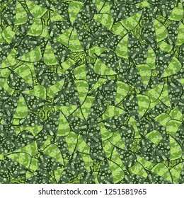 Seamless pattern. Motley-green leaves in random order are placed against the background of the wood-parquet texture. Camouflage style.