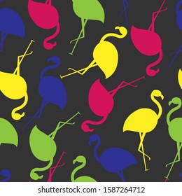 Seamless pattern with multi-colored silhouettes of flamingos on a gray background. Vector. Yellow, green, blue, pink. Suitable for fabric, covers, wrapping paper