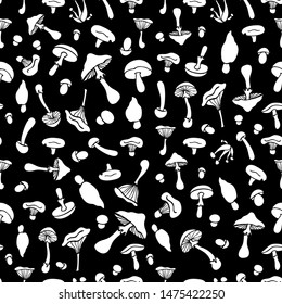 Seamless pattern with mushrooms. White silhouettes of mushrooms on a black background. For decorative fabrics, Wallpaper,packaging and paper.Flat style.Vector file.