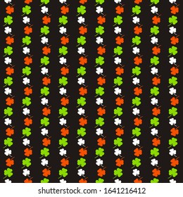 Seamless pattern on the theme of St. Patrick's Day. Black background with white, orange and green shamrocks. Colors of the Irish flag. Pattern for decorating holiday attributes, posters, cards