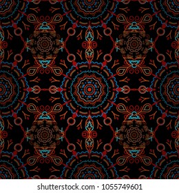 Seamless pattern of orange and red snowflakes and dots on black background. Vector abstract design in orange and red colors.